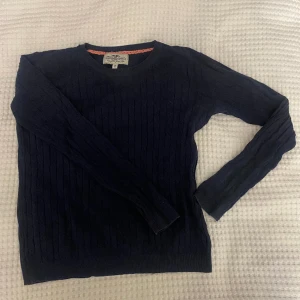 Marinblå kabelstickad tröja - Superfin marinblå kabelstickad tröja i strl 146/152. Knappt använt så väldigt bra skick. Nypris är 299kr, skicka gärna prisförslag. 