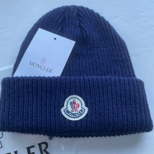 Moncler mössa - Tjo säljer nu en moncler mössa med ett riktigt bra skick som nästan är aldrig använd, man får med påse och moncler kort, den är riktigt bra nu till vintern är one size, perfekt till er kalla vädret i Sverige😀😀