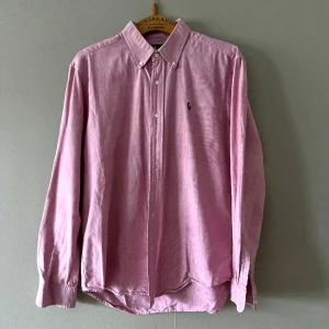 Ralph Lauren-skjorta i grovt tyg, rosa - En rosa Ralph Lauren-skjorta i vävt tyg, lite lätt rosa. Den är vältillverkad och lite grövre i tyget än deras tunnare skjortor. Hjälper min sambo att sälja den 🌸