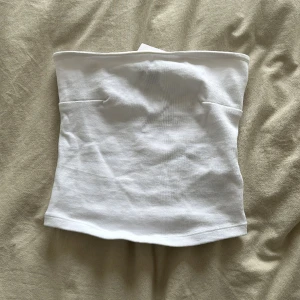 Tubtopp - Vit tubtopp från Gina Tricot. Oanvänd med lapp kvar. Säljes pga köpte fel storlek.  Stretchigt material. Ribbat material.  