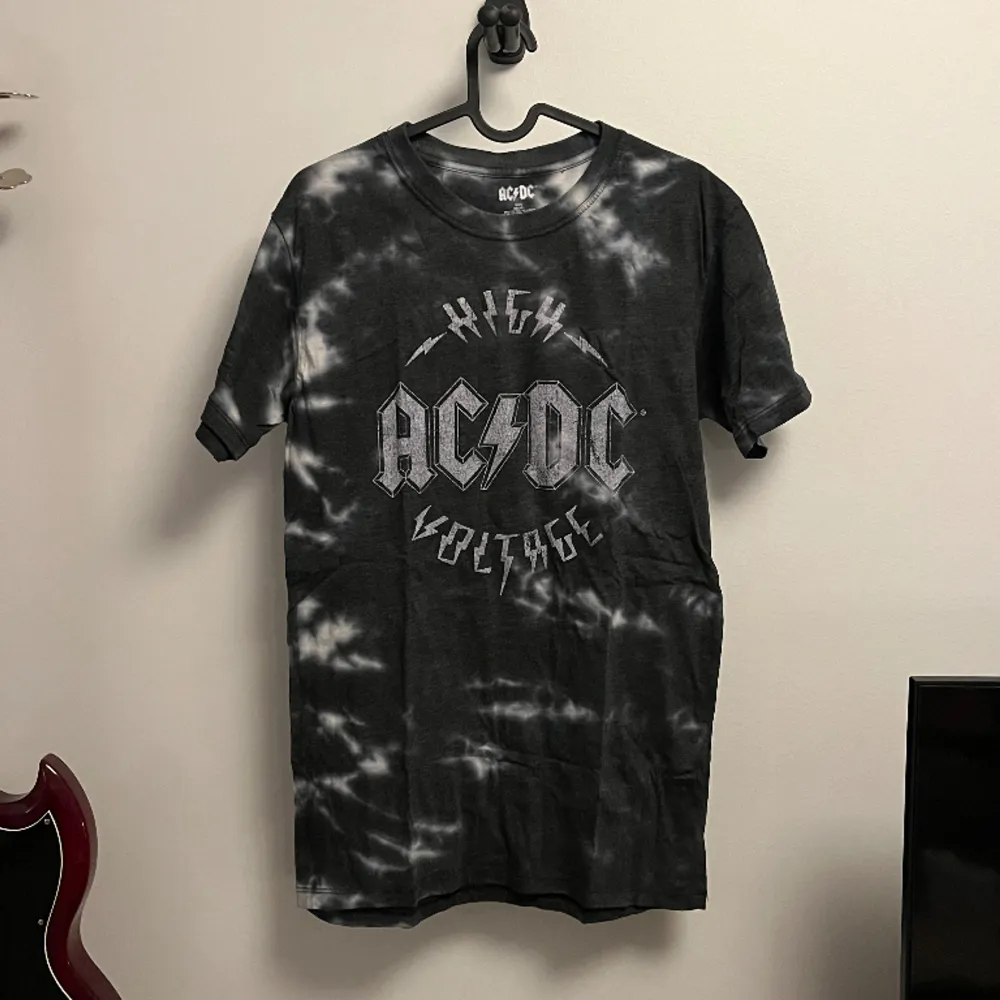 Vit och svart batikmönstrad tshirt med AC/DC tryck på framsidan. T-shirts.