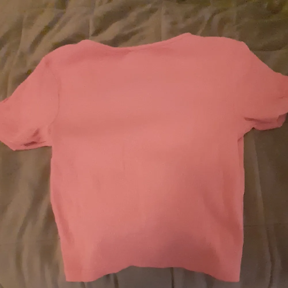 Så fin och sött rosa t-shirt, även magtröja. Super fin detalj med snörre på där fram och lite mörkare i färgen än på bilderna, altså lite mera åt 