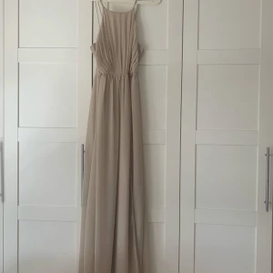 Balklänning  - Endast använd 1 gång! En fin balklänning i champagne med slits på sidan och knappar på ryggen 