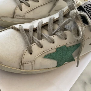 Golden Goose sneakers  - Golden Goose sneakers, som nya endast använda 2 gånger. Vita med grön stjärna och guldig i bakre kanten. Nypris runt 4800 kr