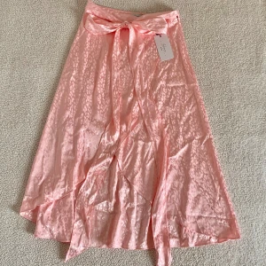 Hanna Schönberg x NA-KD rosa omlottkjol leopardmönster - Otroligt vacker omlottkjol i satin från Hanna Schönbergs kollektion med NA-KD. Ny med tags kvar. Ordinariepris 499kr.