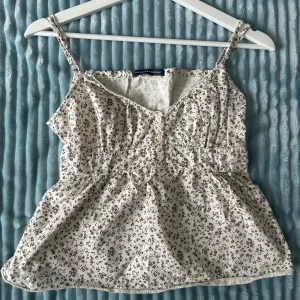 Brandymelville Topp - Så fin topp från brandy melville, köpt på plick! Lite sönder i ena hörnet (se bild 2), men inget som påverkat mig när jag använt den! Köparen betalar för frakten och katt finns i hem 