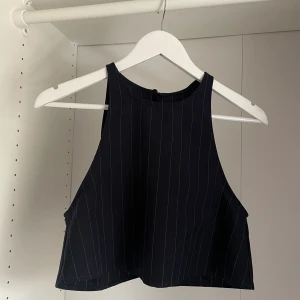 Topp från American Apparel strl S - Kritstreck topp med öppen rygg från American Apparel. I perfekt skick, endast använd ett fåtal gånger