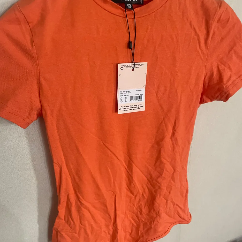 En orange bodysuit perfekt inför sommaren. Helt ny från missguided!. T-shirts.