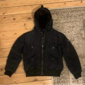 Skitsnygg mörkgrå/svart jacka, påminner jättemycket om Carhartt active jacket. Har en vintage känsla. Köparen står för frakt. Kan mötas i Stockholm och Uppsala.