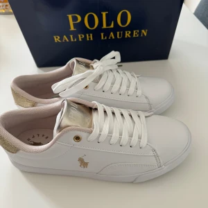 POLO RALPH LAURENTHERON V - Vit / Guld - Hej! Säljer dessa skor då jag beställt fel storlek, de är storlek 39 men passar perfekt till 38.   Kvitto finns med, låda finns med och de är aldrig använda. Endast provade, vid frågor eller intresse kontakta mig!