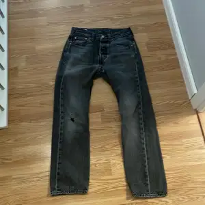 Lite små slitna jeans med ett litet hål på benet 
