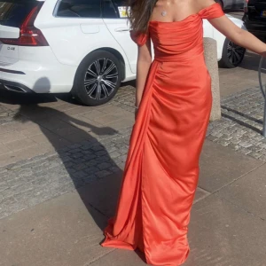 Lång festklänning  - Det är en ganska lång kläning med hängande ärmar. En dragkedja på ryggen. En hög slits som kommer upp till höfterna på en sida. Jag är ca 165cm lång och har klackar på bilden men klänningen blir fortfarande lång på.Använd endast 1 gång. 36-38