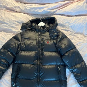 Svart Ralph lauren jacka - Säljer en jätte fin populär Ralph lauren jacka då den är lite stor på mig. Två lagningar som man inte lägger stort märke till och en liten lagning på det man håller i till dragkedjan men inget som syns annars jätte fint skick (köptes från Plick) 