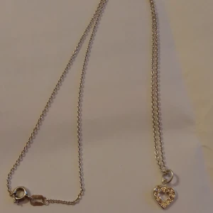 Halsband med hänge av ett hjärta 835 - Fint halsband med hänge av ett hjärta Silver 835 stämpel på låset .Mycket fint skick .