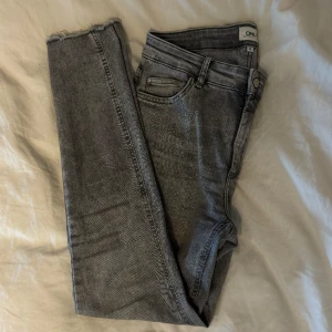 Jeans - Gråa jeans från Only, använda men i fint skick.  Storlek L 32, men sitter lite över ankeln på mig som är 168! Sköna, stretchiga och lite ”fransiga” ned till! Tyvärr blivit för stora för mig. Katt finns i hemmet  Köpare står för frakten 