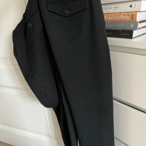 Elvine, Svart, 29/32 (använda 1 gång) - Elvine svart byxa i 64% Polyester, 32% Viscose, 4% Elastane. 9/10. 29/32, ganska slim. Perfekt skick, endast använda en gång. Nypris: 1200kr. Köparen betalar frakt.