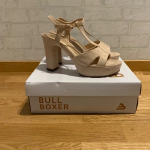 Nude klackskor  - Nude rosa klackar i fake mocka, använt 2 gånger men gick i grus en gång så enda tecken på användning är sulan (se bild 3) annars är de hela och rena. Inköpta i Ryns skor i Västerås, från märket Bullboxer. Klacken är 10cm.