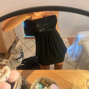 Svart miniklänning  - Säljer denna as snygga svarta axelbandslösa klänning som är as najs me glitter på🥰🥰🥰🥰🥰🥹🧸🧸