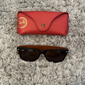 Ray-Ban - Säljer nu mina Ray-Ban New Wayfarer solglasögon med unik orange och blå färgkombination. Perfekt inför sommaren! Använda och är i bra skick. Levereras med orginalfodral. Priset är ej huggit i sten och kan diskuteras. Skriv privat om ni har fråger. 