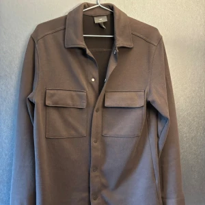 Overshirt brun - Stilig och skön brun/grå overshirt med knappar och dubbel bröstficka från HM!  Nypris: 700kr Skick:9,5/10 knappt använd Storlek: S, passar S-M Pris kan diskuteras! Byten funkar!