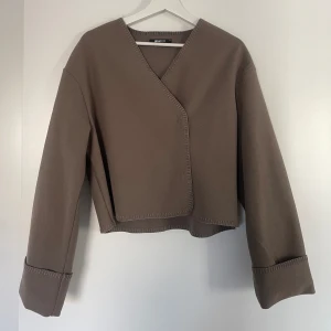 Stitch jacka - Tunn jacka/ kofta från ginatricot i en ljusbrun färg! Använd några få gånger men ser ut som ny, strl s och har en lös passform