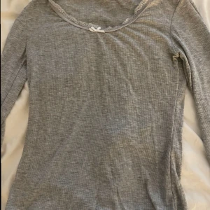 Grå långärmad tröja💗 - Jättefin långärmad ljusgrå tröja från hunkemöller! Så gullig med fin spets och liten roset! Köpt via Sellpy och knappt använd av mig. Inga defekter och i väldigt bra skick. Tror inte den säljs längre. Skriv privat för mer info/bilder