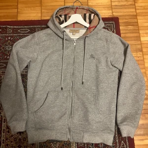 Burberry zip - Säljer en schysst Burberry zip hoodie i färgen grå. Säljer pga den inte passar mig längre. Inga skador eller så och otroligt skön. Priset kan diskuteras