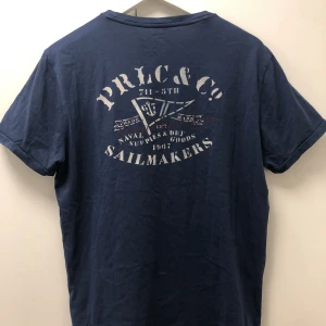 Ralph lauren t-shirt - Extremt efterfrågad ralph lauren t-shirt i perfekt skick. Sjukt eftertraktade med sommrigt tryck i marinblå färg. Skriv för frågor eller fler bilder.