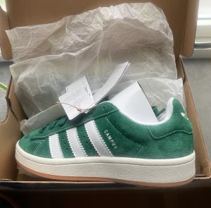 Adidas campus 00s - Gröna adidas campus 00s i storlek 38. Helt nya med lappar kvar!! Beställt från Nelly men ångrade mig med färgen, så säljer vidare!! Nypris 1250kr men slutsålda på de flesta hemsidor. Kan skicka fler bilder om ni vill ha<3