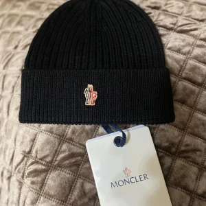 Moncler mössa  - Helt ny och fräsch moncler mössa som passar perfekt för den kommande vintern eller en perfekt julklapp!!!! nfc finns, scan finns och tags som medföljer!!  Kan mötas upp och frakta 