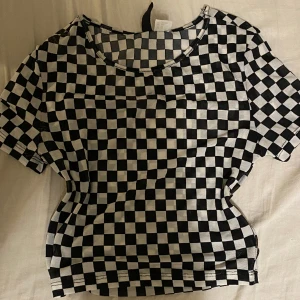 Croppad T-shirt  - Croppad T-shirt från hm divided. Aldrig använd osäker på nypris. Sitter fint längs kroppen men gillar inte mönstret. Hör av dig vid frågor!