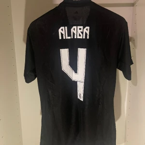 Svart Real Madrid tröja, Alaba #4 - Real Madrid🏆 2022🏆 I nyskick🏆 Alaba, #4🏆 För endast 449kr kan detta världskända matchställ bli ditt! Hör av dig vid funderingar. 