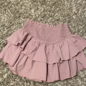 Minikjol  - Så söt gammalrosa minikjol med volanger. Hade tidigare inbyggda shorts, men som satt väldigt konstigt och är avklippta - men inget som märks 