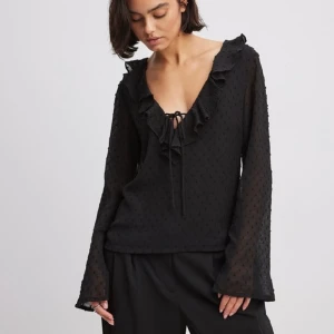 Blus med volanger - Såå snygg svart blus med volanger! Oanvänd med prislapp kvar😍. Perfekt som julklapp även! Skriv för fler bilder eller frågor☺️.