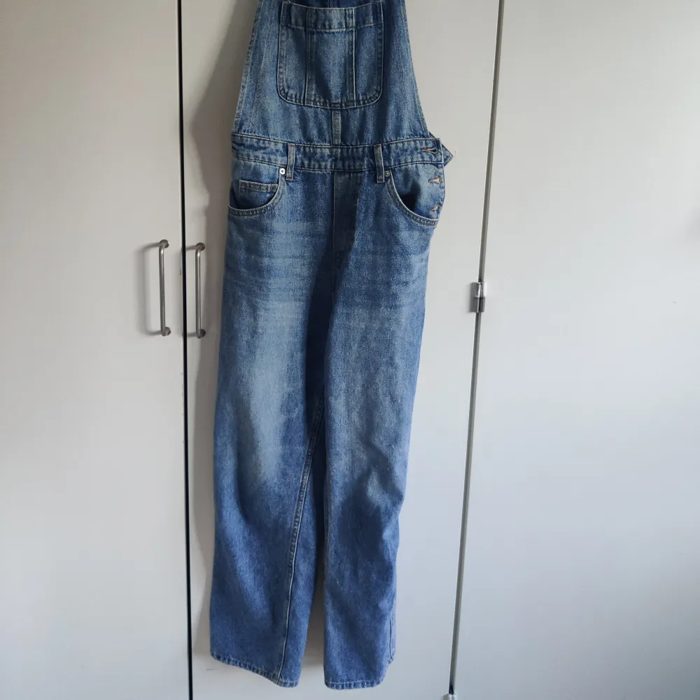 Blå hängselbyxor/dungarees i jeans från H&M. Storlek 34. Justerbara band. Fint skick, säljes då de inte passar mig. Jeans & Byxor.