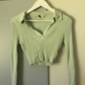Grön croppad tröja - Supersnygg grön croppad tröja. Med krage och v-ringning. Storlek S. Stretchig och superbekväm. 