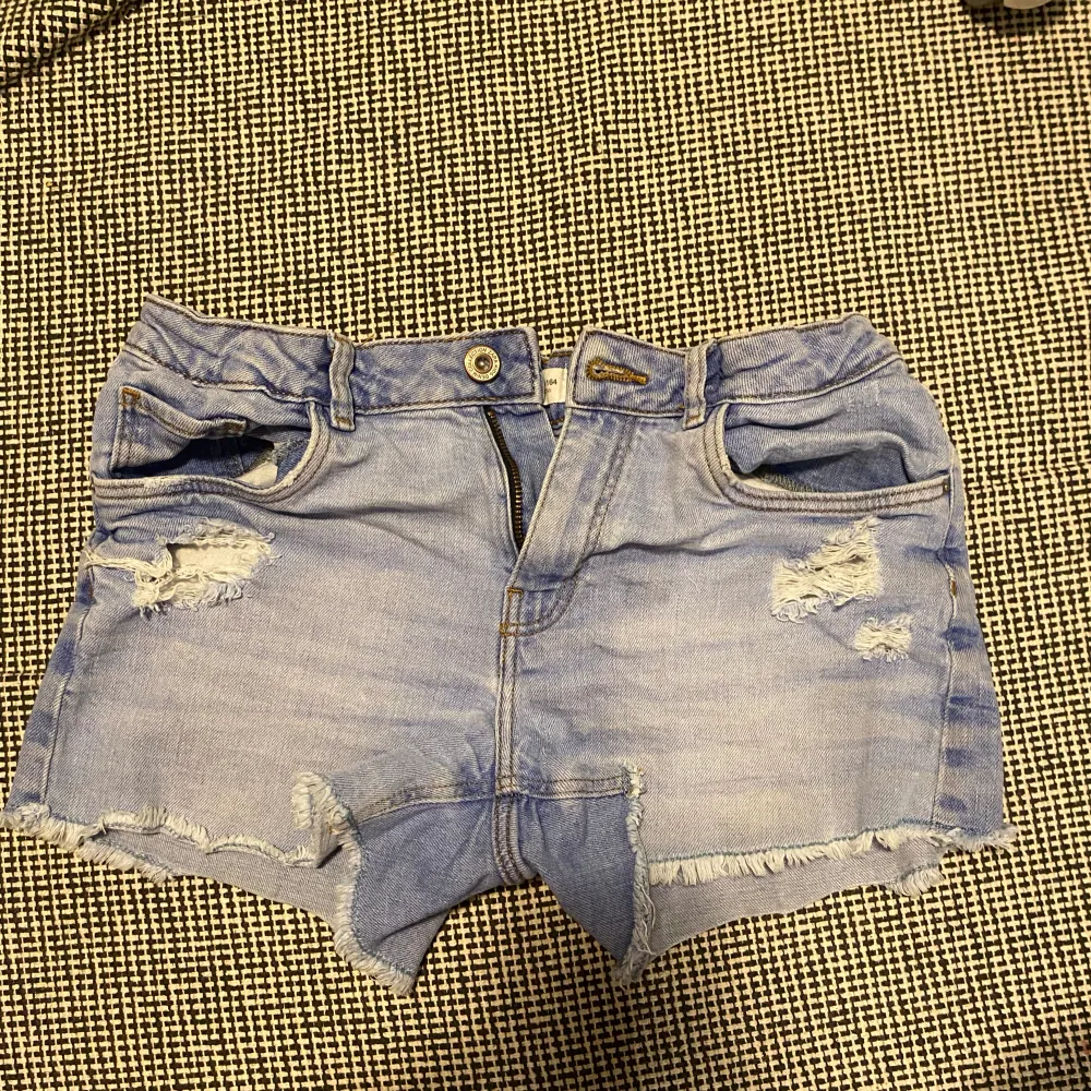 Super snygga lågmidjade blåa shorts med slitningar ifrån Zara:) De är köpa från barnavdelningen men passar mig som är 167💞Fint skick!!. Shorts.