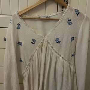 Somrig blus med blommor  - Säljer denna blus i väldigt bra skick, inga skavanker. Ganska gammal, säljs inte längre på flash men väldigt sparsamt använd, använd kanske Max 7 gånger. Storlek M men passar även S. 