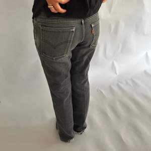 Utsvängda Levis jeans med en liten slitt längst ner. Innerbenslängd: 78 cm Midjemått (sida till sida): 38cm