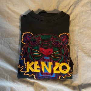 Kenzo sweatshirt - Kenzo tröja svart i riktigt fint skick förutom ett pyttelitet hål fram vilket du ser på bild nr1. Storlek s. 
