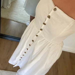 Vit långklänning  - Väldigt fin lång klänning med knappar, jag är 170 cm och klänningen går lunder mina knän. Hör av er vid frågor eller om ni vill ha fler bilder 