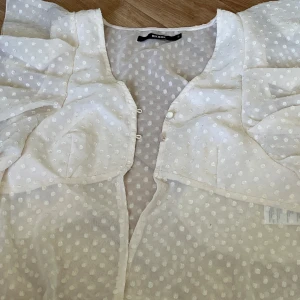 Bik bok ljus rosa kofta med flare - En ljus rosa kofta med flare på axlarna med två knappar i fram