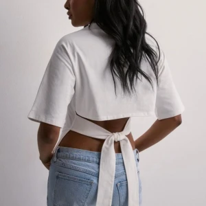 T-shirt med öppen rygg - Säljer den här populära toppen med öppen rygg från Nelly. Strl Xs. Använd en gång, nyskick! Slutsåld på hemsidan🤍