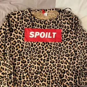 Säljer en cool leopardmönstrad tröja med texten 'SPOILT' i vitt på en röd bakgrund. Tröjan är långärmad och har en avslappnad passform. Perfekt för en avslappnad och trendig look. 🐆