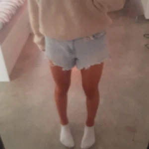 Ljusa jeansshorts med fransar - Säljer ett par ljusa jeansshorts med fransar i nederkanten. De är perfekta för sommaren och har en avslappnad, loose passform. Shortsen är i nyskick och passar bra till både vardag och fest. Perfekta att matcha med en mysig tröja eller en snygg topp! Nypris ca 249kr Från Zara! 