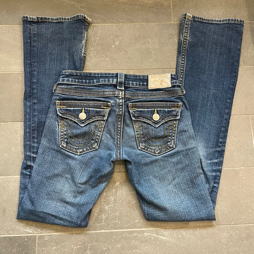 Säljer ett par lågmidjade True Religion Jeans som är bootcut. Slitna längst ner och har tyvärr har det gått sönder lite där bak vid fickan och har en pytteliten fläck (Bild 3-5). Annars är dem i fint skick.. Jeans & Byxor.