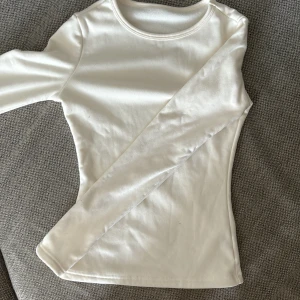 Vit långärmad tröja - Säljer en vit långärmad tröja i bomull. Tröjan är i nyskick och har en normal passform. Perfekt för höst och vinter då den är mjuk och varm på insidan💕