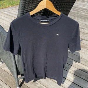 J.lindeberg T-shirt  - Säljer denna svarta j.lindeberg T-shirt i storlek M. Modellen på bilden är 184cm lång och väger 70kg. Orginalpriset är 399kr, vårt pris är 199. Tveka inte på att kontakta vid frågor. Pris kan gå ner vid snabb affär 🙌😁