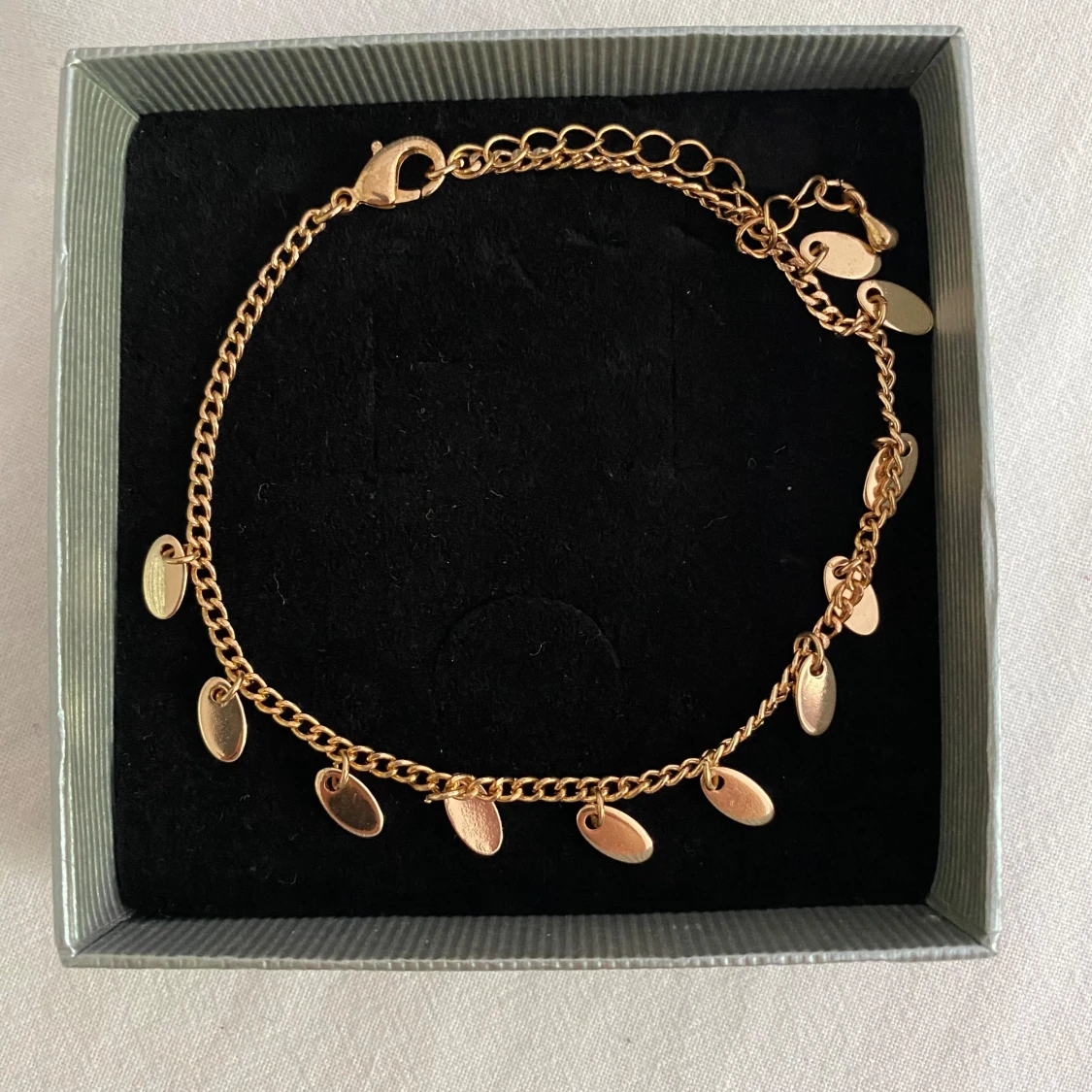 Guldarmband med små hängande berlocker