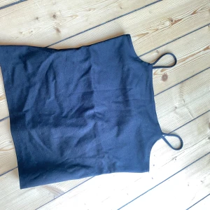 Svart ärmlös linnetopp - Säljer en enkel och stilren svart linnetopp. Den är ärmlös med smala axelband och passar perfekt till både vardag och fest. Toppen är i storlek s och är tillverkad i ett mjukt och bekvämt material.